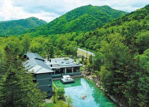 an aerial view of a house on a river at Okujozankei Onsen Kasho Gyoen in Jozankei