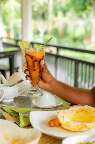 een persoon met een limoen op een tafel bij Evergreen Villa - Sinharaja in Deniyaya