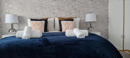 a bedroom with a blue bed with two lamps at Contractors & Families Large Drive M1 M69 Wifi in Leicester