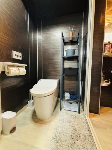 a bathroom with a toilet and a black wall at Shimokitazawa Cozy Apartment 202 in Tokyo