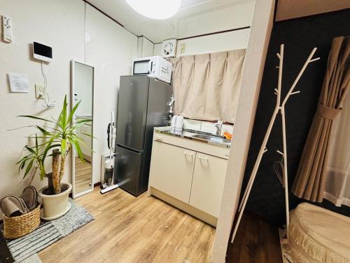 a small kitchen with a refrigerator and a sink at Shimokitazawa Cozy Apartment 202 in Tokyo