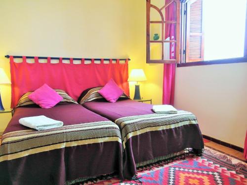 a bedroom with a large bed with pink pillows at Christina's House in Asilah