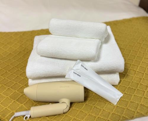 a hairdryer and towels on a table next to a bed at New! Stay in Kamata West Exit Gourmet Street! in Tokyo