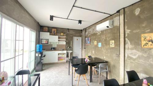 a room with a table and chairs and a kitchen at Kangaroo Residence Udonthani in Udon Thani