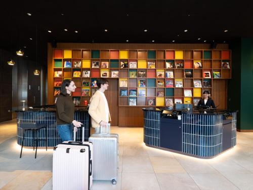 two people standing in a lobby with their luggage at Tokyu Stay Hakata in Fukuoka