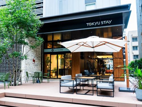 a table with an umbrella in front of a building at Tokyu Stay Hakata in Fukuoka