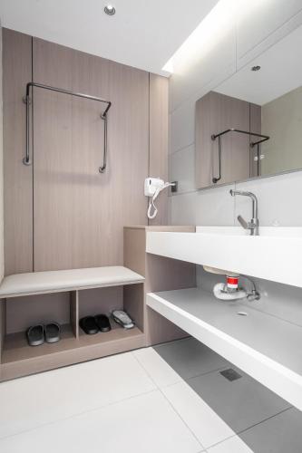 a bathroom with a sink and a mirror at Ancient City District Ai Shan Hotel in Lijiang