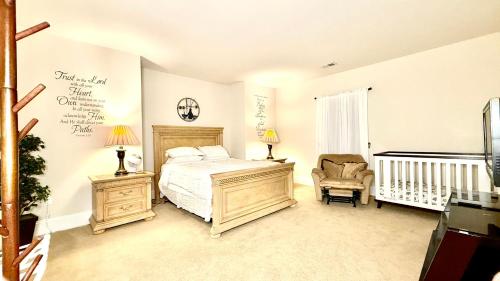 una camera con letto, sedia e culla di Luxurious 2BR Movie Theater Game Room Full Kitchen Gym a Clifton