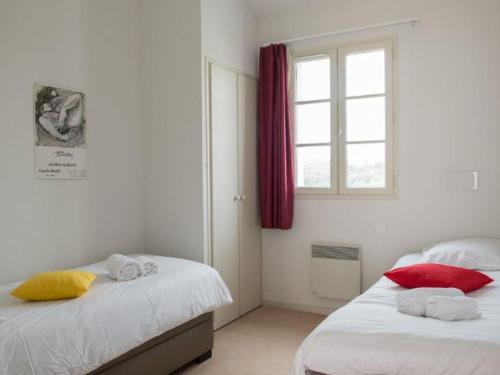 ein Schlafzimmer mit zwei Betten und einem Fenster in der Unterkunft Maison avec Terrasse, 2 Chambres, 4 Pers. - API-1-52-1368 in Carla-Bayle