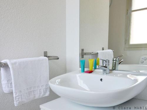 ein weißes Badezimmer mit Waschbecken und Spiegel in der Unterkunft Maison avec Terrasse, 2 Chambres, 4 Pers. - API-1-52-1368 in Carla-Bayle