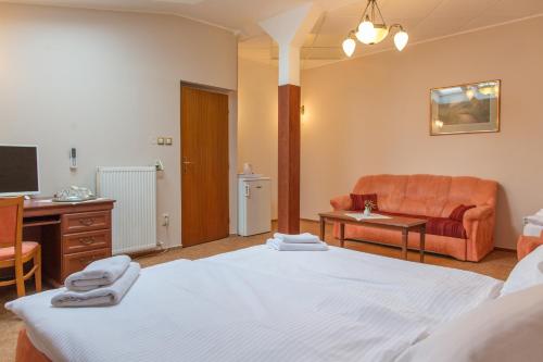 a hotel room with a bed and a couch at Hotel Grand in Žilina
