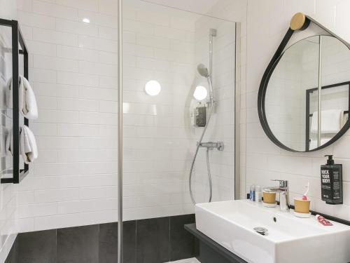 een witte badkamer met een wastafel en een douche bij ibis Avignon Sud in Avignon