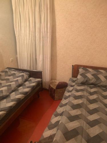 een slaapkamer met 2 bedden naast een raam bij Джермук 3-комнатная квартира in Dzjermoek