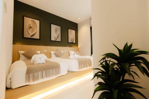 a bedroom with two beds and a potted plant at Rivla A Pool Villa in Ao Nang 