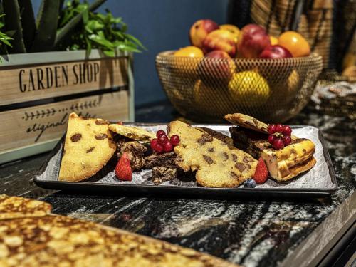 un piatto di cibo con pane e frutta su un tavolo di Mercure La Roche Sur Yon a La Roche-sur-Yon
