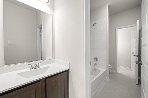 een witte badkamer met een wastafel en een bad bij Luxury 6 Bedroom Home in Denton