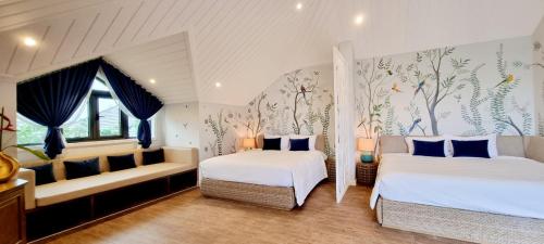 a bedroom with two beds and a couch at LumiShora Villa - Bai Truong, Phu Quoc in Phú Quốc