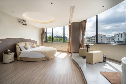 a bedroom with a bed and large windows at Ancient City District Ai Shan Hotel in Lijiang