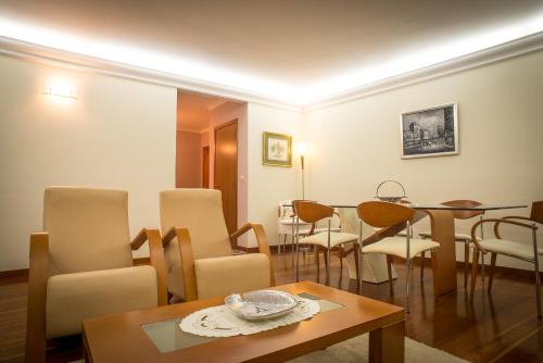 a living room with chairs and a table and a dining room at Helen´s House Apartment in Câmara de Lobos