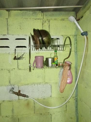 a shelf with pots and pans on a brick wall at Easy Life Hut in Ko Bu Bu