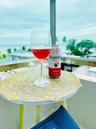 ein Glas Wein und eine Flasche auf einem Tisch in der Unterkunft เดอะซันเซ็ท บางแสน Exclusive Top Floor in Chon Buri