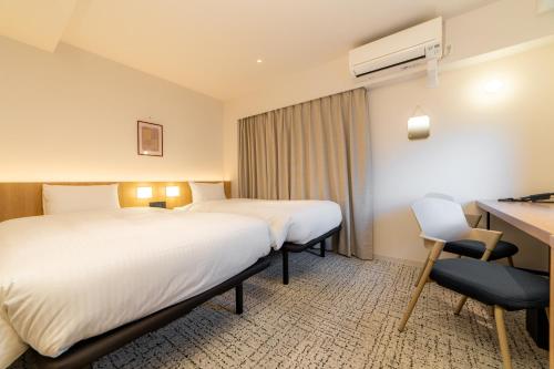 Postel nebo postele na pokoji v ubytování Henn na Hotel Express Osaka Namba Nipponbashi