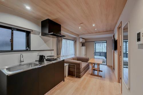 een keuken met een spoelbak en een woonkamer bij AURA YUZAWA Apartment Hotel - 1Bedroom Apartment with Living Dining Kitchen Sleeps 2 to 4, Bedroom with 2-Double Bed, Living Room with 1-Sofa Bed in Yuzawa