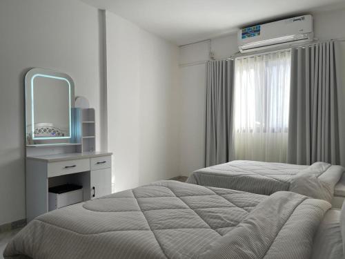 ein Hotelzimmer mit zwei Betten und einem Spiegel in der Unterkunft Furnished 2BR Central Al Ain in al-Ain