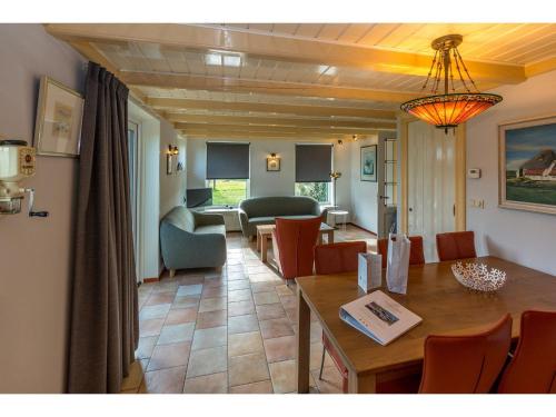 een eetkamer en woonkamer met een tafel en stoelen bij Lovely Holiday Home in Texel near Sea in Oost