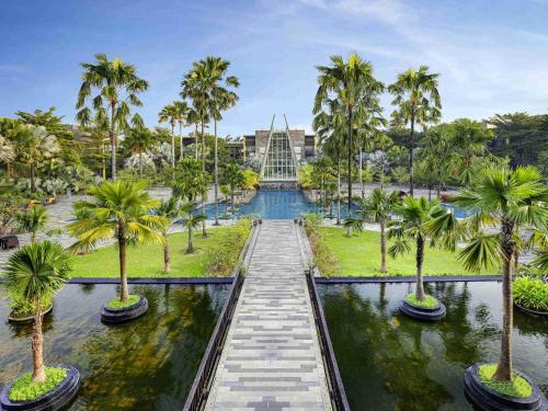Blick auf einen Park mit Palmen in der Unterkunft Novotel Palembang in Palembang