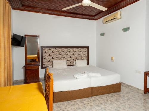 ModakandiyaFlamingo Lake Resort Tissamaharama的一间卧室，里面有一张床和一个吊扇