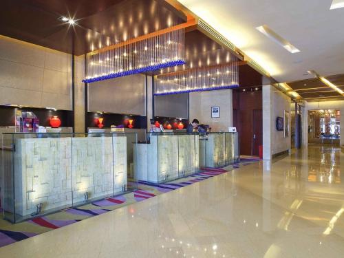 a restaurant with a bar in the middle of a building at Grand Mercure Beijing Central in Beijing
