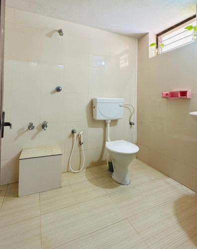 a bathroom with a toilet and a shower at HARSHAM Eco Village in Puthuppādi