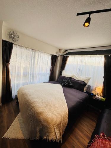 a bedroom with a large bed and a window at Shimokitazawa Cozy Apartment 401 in Tokyo