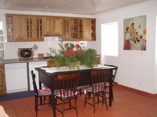 a kitchen with a table with flowers on it at Quinta da Abegoaria in Abegoaria