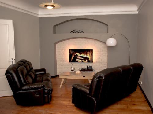 a living room with two leather chairs and a fireplace at Large Vacation Apartments in the Old Town in Riga
