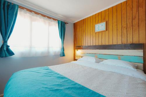 a bedroom with a large bed with a window at Algarrobo Cabaña a 2 cuadras Playa El Canelo+Wifi in Algarrobo