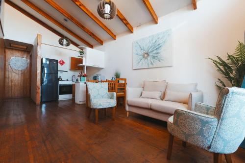 a living room with a couch and chairs and a kitchen at Algarrobo Cabaña a 2 cuadras Playa El Canelo+Wifi in Algarrobo