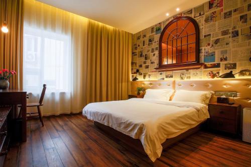 a bedroom with a large bed and a window at Kaiyue Hotel Qingdao in Qingdao