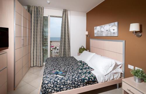 een slaapkamer met een bed en een raam met uitzicht bij Residence T2 in Rimini