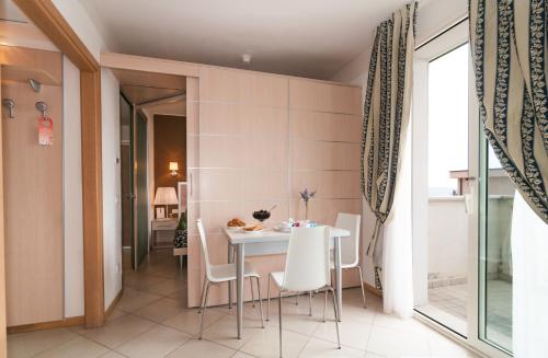 a dining room with a white table and chairs at Residence T2 in Rimini
