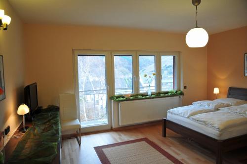ノイマゲン・ダオンにあるFerienwohnung Noviomagusのベッドルーム1室(ベッド1台付)、花の咲く窓が備わります。