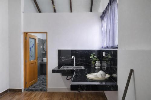 a bathroom with a black counter and a sink at Nisadi Villa in Bentota