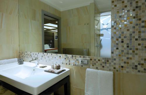 a bathroom with a sink and a mirror at Harry's Bar Trevi Hotel & Restaurant in Rome