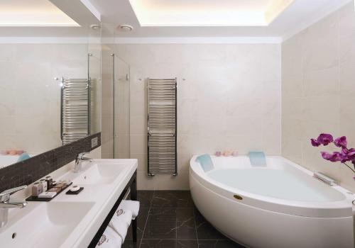 a white bathroom with a tub and a sink at Harry's Bar Trevi Hotel & Restaurant in Rome