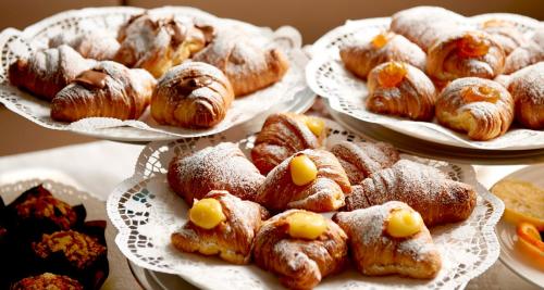 a bunch of pastries on plates on a table at Harry's Bar Trevi Hotel & Restaurant in Rome