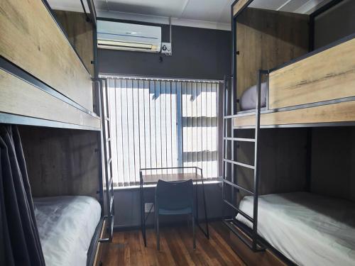 een slaapzaal met 2 stapelbedden en een stoel bij Beds Inn George in George