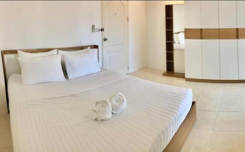 a bedroom with a bed with two towels on it at Grandview Ladprao Hotel in Bangkok