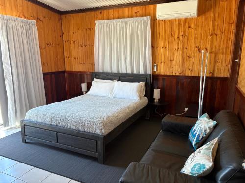 a bedroom with a bed and a couch at Rustic Retreat Esperance in Esperance