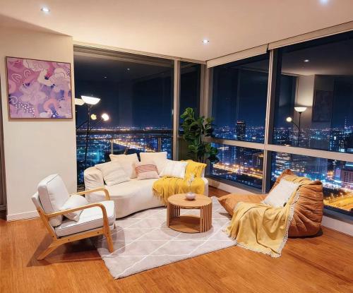 a living room with a couch and a large window at Spacious landmark in the heart of CBD in Melbourne